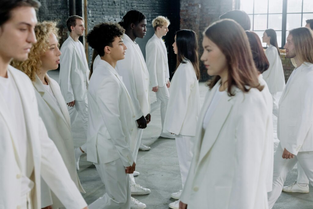 como-explicar-hallowenn-para -crianças Grupo de jovens vestidos de branco em contraste com um fundo escuro, representando a celebração do Dia de Todos os Santos.
