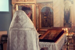 Sacerdote celebrando a liturgia na igreja, em frente ao ícone, ilustrando o Lex Orandi, Lex Credendi.