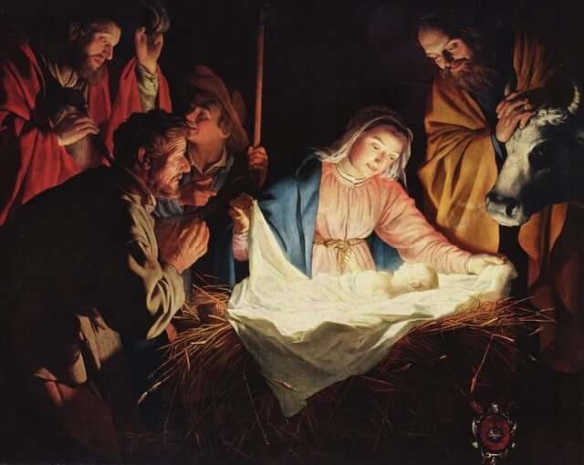 uma imagem do presépio formado por Maria, José e os reis Magos admirando o Menino Jesus em uma majedoura de onde ele emana uma intensa luz.