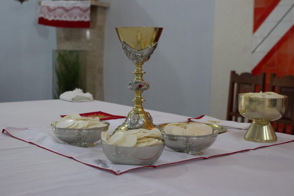 presença-real-na-eucaristia um altar da Igreja com um cálice dourado e patenas com hóstias sagradas